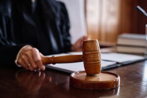 A Supreme Court judge striking a wooden gavel on a sounding block.