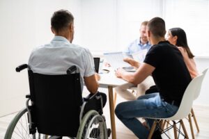 Disabled Individuals in Wheelchairs Attending a Workplace Business Meeting.