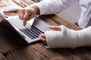 Close-up of a Businessperson's Hand with an Injury Using a Laptop.