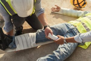 A safety team provides gauze to assist an injured employee after an accident. 