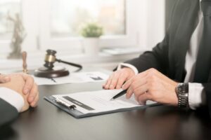 A male lawyer reviews contract papers, consulting with a client. This scene represents the concept of law and legal services.