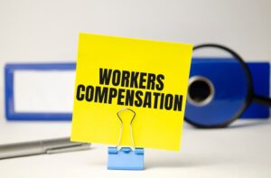 Workers compensation on yellow sticker and blue file folder